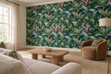 Leaf-patterned green feature wall beside a tall window, viewed from an ivory sofa across an oak coffee table and tobacco-colored chair.