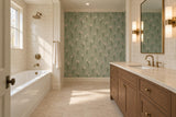 White bathtub with cream tile beside a brown wood vanity, brass-accented mirror lights and a sage daisy-patterned wall.