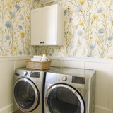 Floral pattern Meadow Flicker Wallpaper with blue and yellow flowers on an off-white background.
