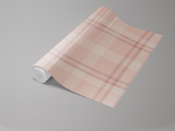 Roll of blush plaid wallpaper with a soft, painted texture.