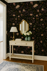 Berry Meadow wallpaper in black with pink floral and berry pattern, seen on a wall.

