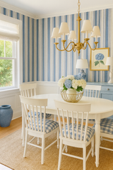Blue and beige striped wallpaper with vertical grainstripe pattern, complemented by white trim and window.
