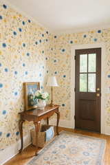 Floral print wallpaper with blue and yellow cornflower pattern on cream background.