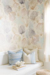 Low Tide Relics wallpaper with seashell and starfish pattern, over a white seating area with blue pillows.