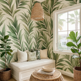 Green leaf-patterned wallpaper with tropical style, featuring palm fronds and lush foliage, styled in a bright, inviting room.
