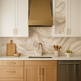 Mineral drift wallpaper with a swirling tan and beige pattern behind a kitchen counter and cabinets.
