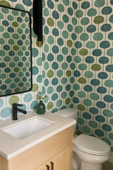 Patterned wallpaper with green and teal foliage print on white background.