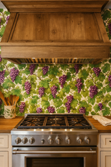 Grapevine-patterned wallpaper with purple grapes and green leaves, covering a kitchen wall behind a stainless steel gas range.