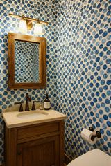 Bubbled Ink Wallpaper with blue polka dot pattern, covering the bathroom walls.