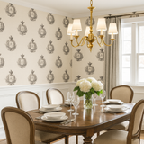 Monogram Manor Wallpaper with crest pattern on a light neutral textured surface.
