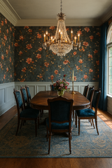 Floral bloom wallpaper with orange flowers on a teal background, against a wainscoted wall.