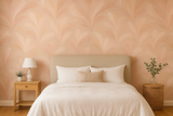 Rosewater veil wallpaper with floral patterns, in a peach tone, covering an entire bedroom wall.
