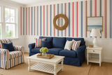 Nantucket Stripe Wallpaper featuring red and blue vertical stripes, in a coastal-style living room setting.
