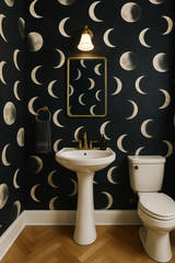 Lunar Veil wallpaper with a moon phase pattern on a dark blue background covering the bathroom wall.
