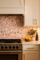 Rosetta Terrazzo wallpaper in pink by unknown brand, covering a kitchen backsplash with colorful stone pattern.
