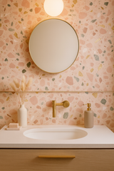 Rosetta Terrazzo wallpaper featuring a playful terrazzo pattern of pink, green, and gold accents.