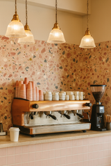 Rosetta terrazzo wallpaper featuring a pattern of colorful chips, shown in a cafe setting.