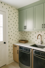 Palm printed wallpaper with green palm tree pattern, set in a laundry room.
