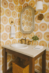 Yellow patterned wallpaper with concentric circles, and octagonal mirror with silver frame.
