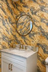 Terra Fossil wallpaper with marbled texture and yellow-gold and gray coloring, adorning a powder room with bronze fixtures.
