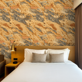 Terra Fossil wallpaper with stone pattern, covering a bedroom wall behind a bed.
