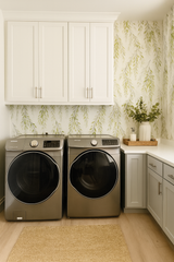 Weeping Grove wallpaper with leaf pattern and natural tones, showing a laundry room setting.