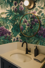 Emerald Cascade Wallpaper with green floral pattern, botanical leaves, and purple flowers on an off-white background.
