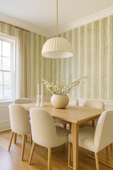 Green and white Fernward Wallpaper with a fern leaf pattern, styled on a dining room wall.