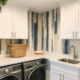Gouache Drift wallpaper with abstract vertical brushstrokes in navy, beige and white.
