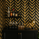 Gold wallpaper by Zulu featuring a black background with a bold, geometric chevron pattern.
