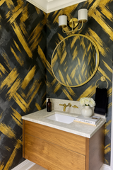 Brushfire Noir wallpaper with gold accents, featuring a painted brush stroke pattern and black background.
