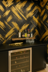 Brushfire Noir Wallpaper with a gold and black painted pattern and abstract brushstroke design.
