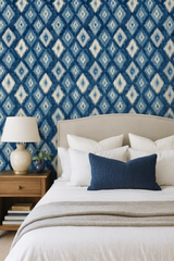 Indigo Mirage wallpaper with diamond ikat pattern on the wall behind the bed.