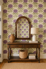 Floral wallpaper featuring purple blossoms by Wallshoppe, above dark wood console table, with vintage-inspired, decorative pattern.