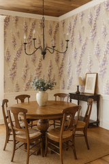 Floral wallpaper with lavender and beige hues, patterned in a dining room with wooden table and chairs.