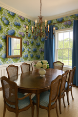 Hydrangea Rhapsody Wallpaper with blue and purple floral pattern, covering the wall in a dining room setting.