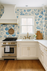 Blue and white teacup wallpaper with toile pattern, set within a traditionally styled kitchen.
