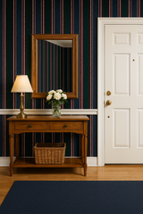 Equestrian stripe wallpaper with navy, green, and red stripes, covering a wall with a mirror and table.