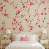 Blossom Script wallpaper with pink floral pattern, covering a bedroom wall behind a bed.

