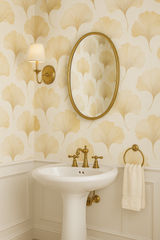 Golden ginkgo wallpaper with a leaf pattern, reflecting in an oval mirror.
