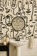 Lineage Wallpaper featuring face line art, by York Wallcoverings, in a bathroom setting.
