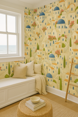 Santorini Steps Wallpaper featuring a village pattern, by Wallshoppe, with white and blue buildings, greenery, and a staircase.
