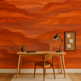 Orange painted canyons wallpaper with wavy pattern, styled behind a wooden desk and chair.
