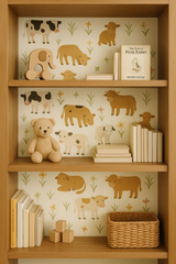 Pasture Parade Wallpaper with cows and meadow flowers print, on a wooden bookshelf filled with toys and books.
