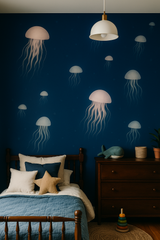Moonlit Drifters Wallpaper with jellyfish pattern on a dark blue wall in a styled children’s bedroom.