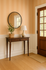 Peach blush plains wallpaper with vertical stripes, neutral tone, decorating a hallway with dark wood furniture.
