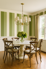 Green striped wallpaper with vertical stripes, evoking an olive grove, with a traditional dining room setting.
