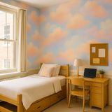Cloudscape wallpaper with blue and peach clouds, next to a bed, desk and window.
