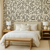 Haring Playhouse Wallpaper with cartoon people pattern on bedroom wall.
