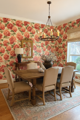 Floral peony wallpaper with red blossoms and green leaves, patterned throughout a dining room setting.
